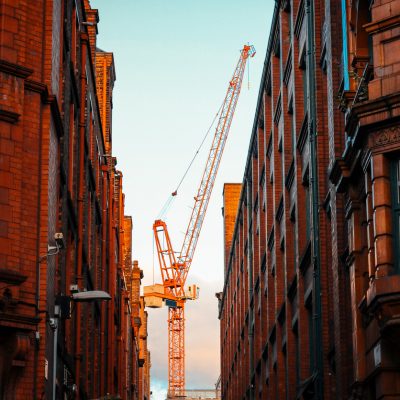 Crane surrounded buy buildings.